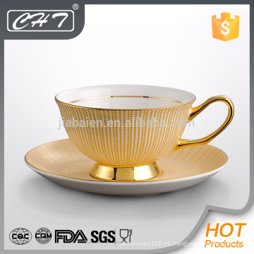 Elegante raya de oro decorado taza de cerámica y plato conjunto con la mano